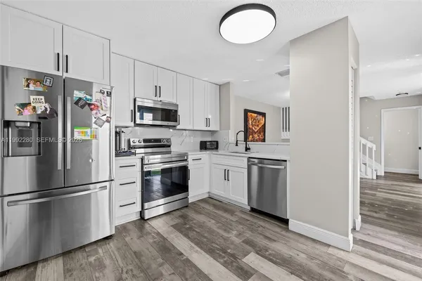 a kitchen with cabinets stainless steel appliances and a window