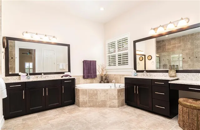 a spacious bathroom with a tub sink and mirror