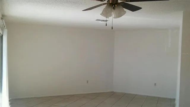a view of a room with a ceiling fan and a fan