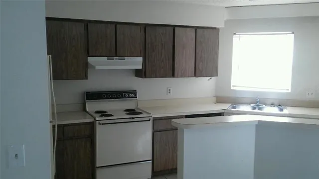 a kitchen with granite countertop a sink cabinets and stainless steel appliances
