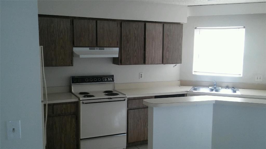 3648 Meriden Avenue Oldsmar, FL 34677 - Photo 3 of 5 a kitchen with granite countertop a sink cabinets and stainless steel appliances