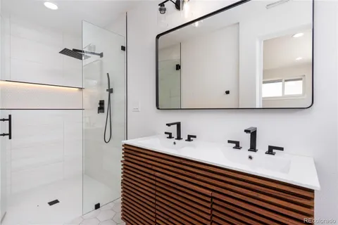 a bathroom with a sink a mirror and shower