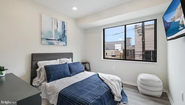 a bedroom with a bed and a large window