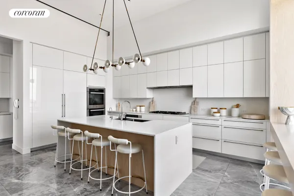 a kitchen with a sink and chairs