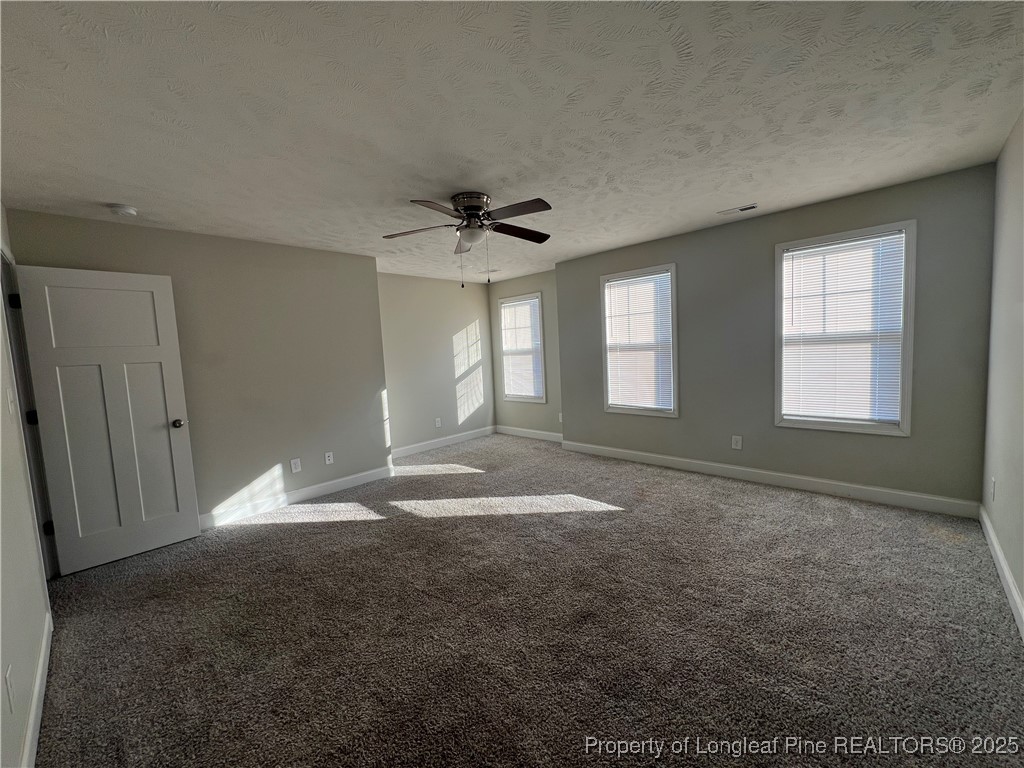 1628 Strickland Bridge Road Fayetteville, NC 28304 - Photo 12 of 20 en empty room with windows and ceiling fan