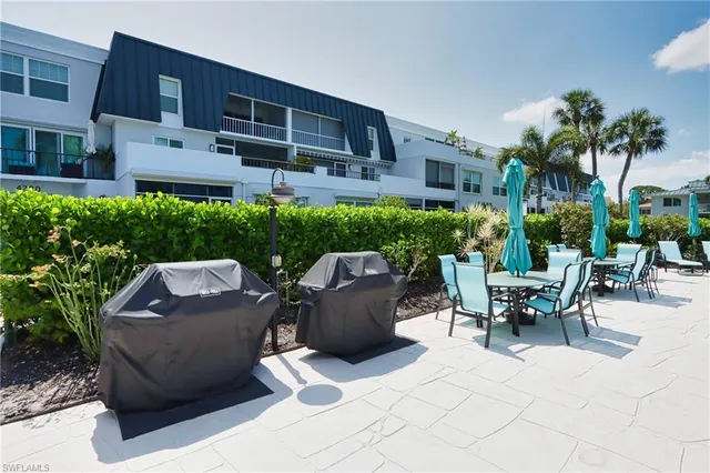 a view of a patio with couches table and chairs and potted plants