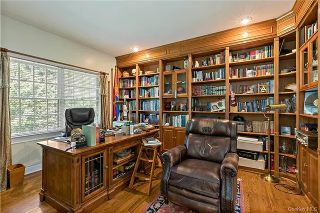 a view of a workspace with furniture and a large window