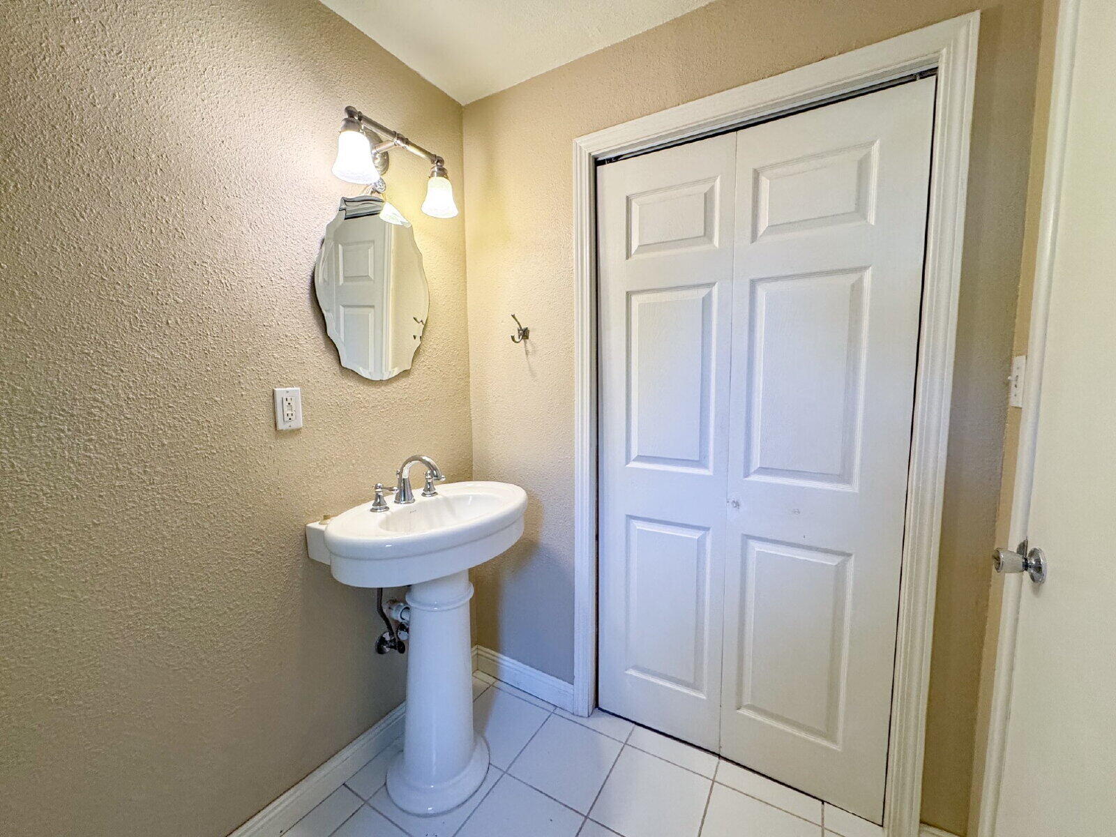 2909 Canton Avenue Lubbock, TX 79410 - Photo 12 of 18 a bathroom with a sink a light fixture and a mirror
