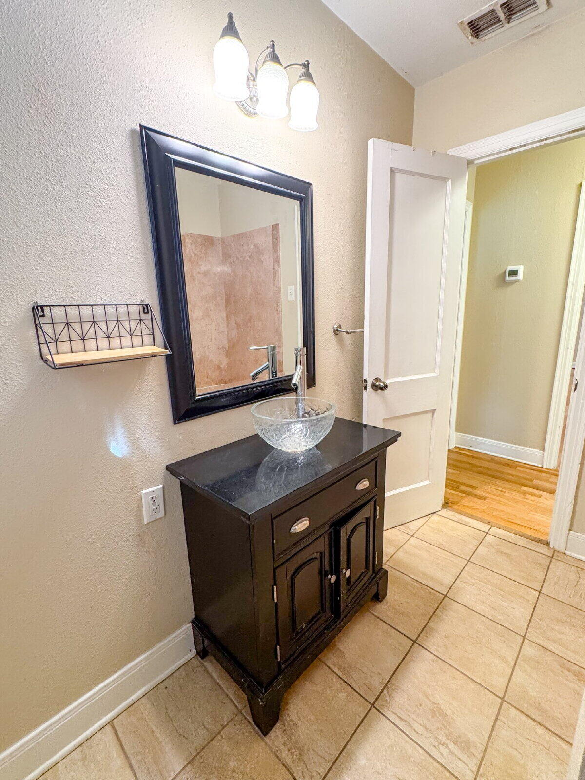 2909 Canton Avenue Lubbock, TX 79410 - Photo 14 of 18 a bathroom with a sink a mirror and a shower
