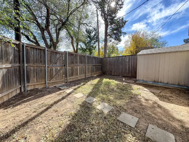 a view of small yard with wooden fence