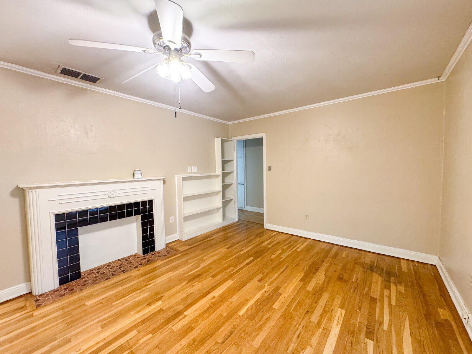 2909 Canton Avenue Lubbock, TX 79410 - Photo 4 of 18 a view of empty room with a fireplace ceiling fan and wooden floor