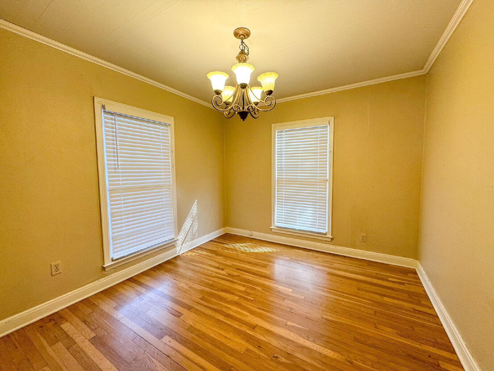 2909 Canton Avenue Lubbock, TX 79410 - Photo 5 of 18 a view of an empty room with a window and wooden floor