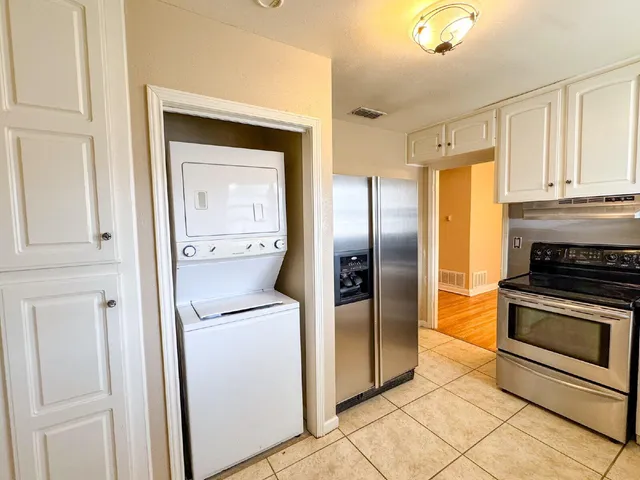 a kitchen with stainless steel appliances granite countertop a refrigerator and a stove top oven