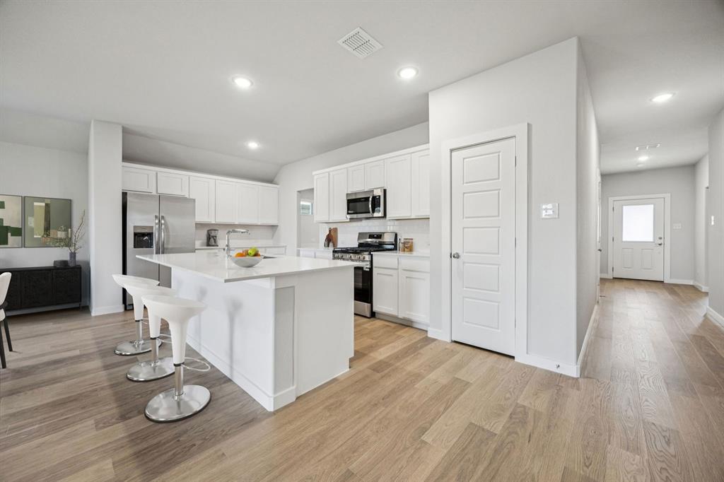 475 Sierra Ridge Lavon, TX 75166 - Photo 5 of 36 a open kitchen with white cabinets and stainless steel appliances