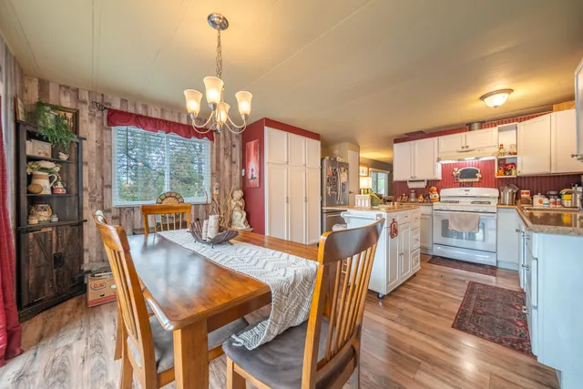 a dining room filled chandelier and wooden floor