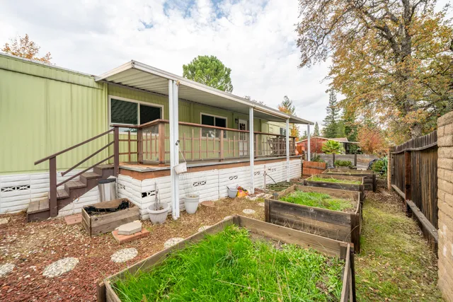 a view of a house with backyard and wooden fence