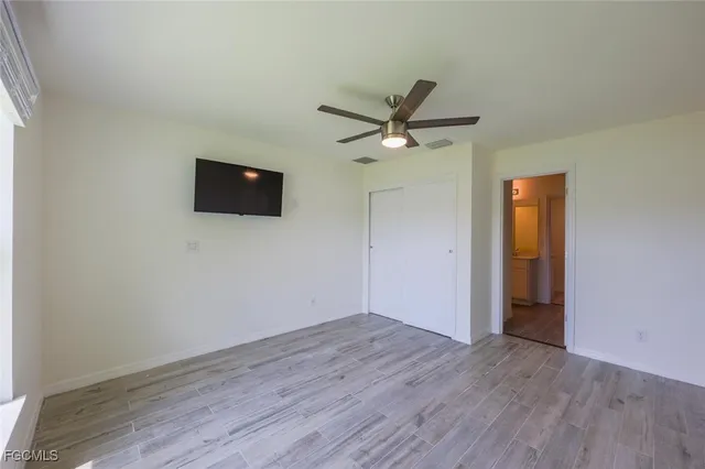 an empty room with wooden floor and windows