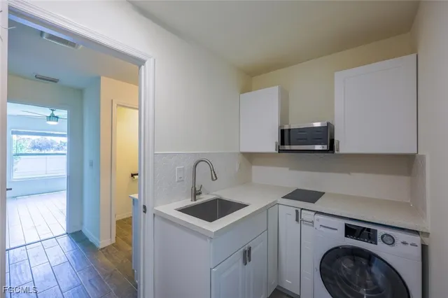 a view of a kitchen with sink and washing machine
