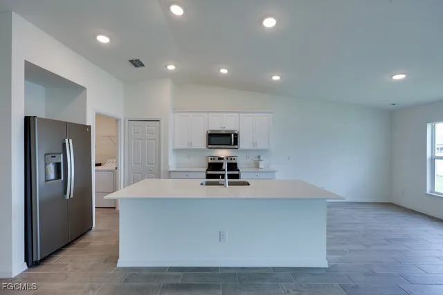 a view of a kitchen with refrigerator stove and wooden floor