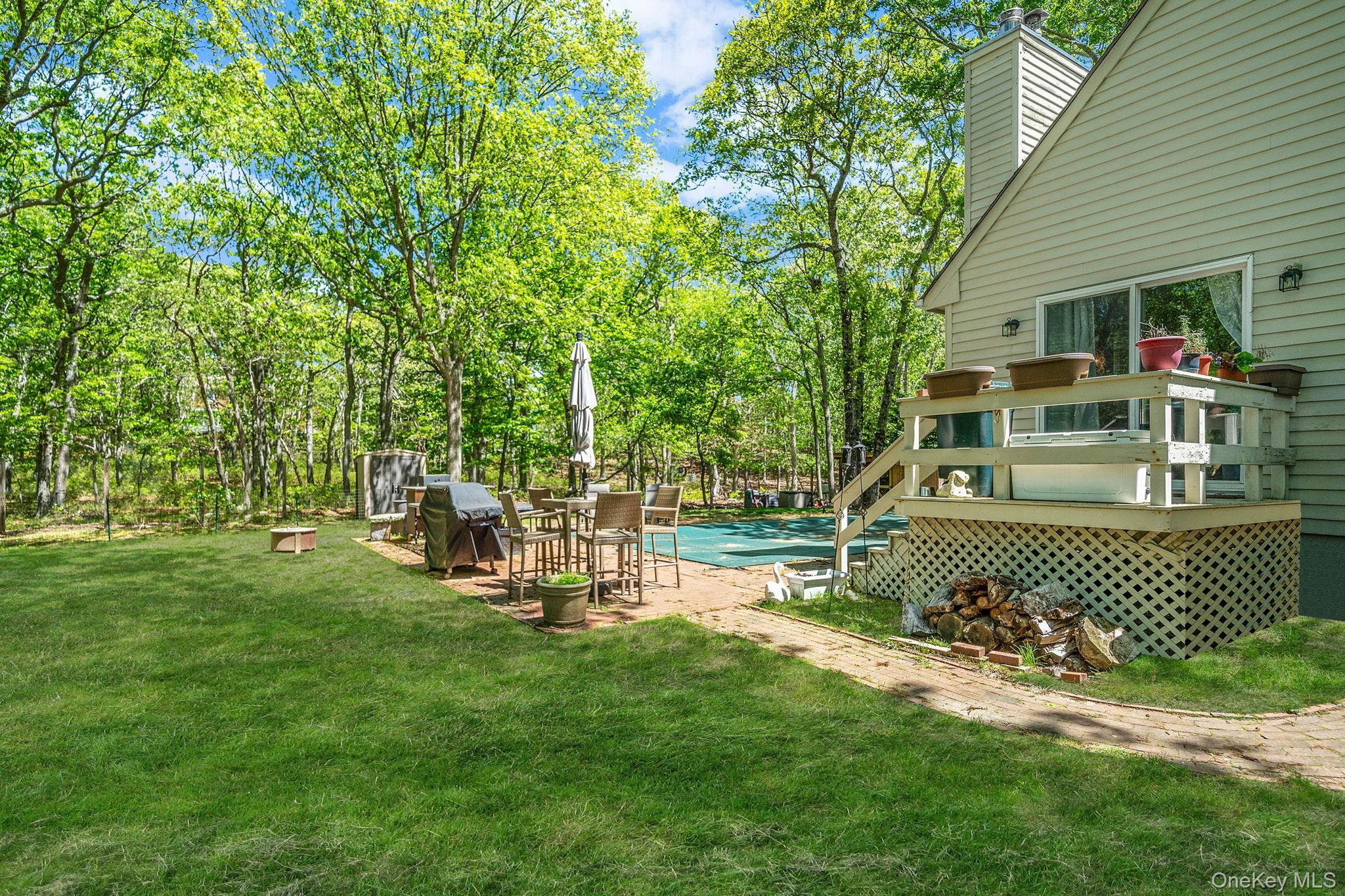 28 Huntting Road East Hampton, NY 11937 - Photo 12 of 14 View of grassy yard with a wooden deck and a covered pool