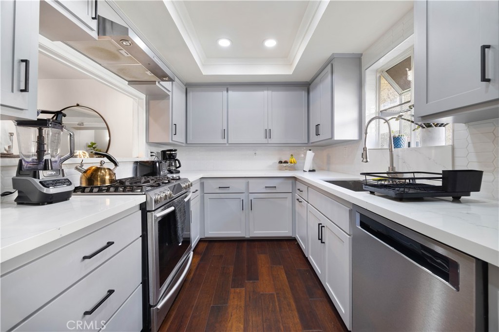 2518 Curtis Avenue, Unit 3 Redondo Beach, CA 90278 - Photo 10 of 35 a kitchen with a sink dishwasher a stove and white cabinets with wooden floor