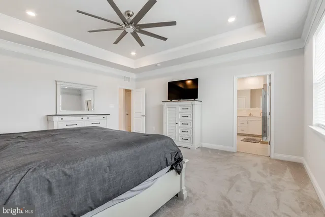 a spacious bedroom with a bed and a flat screen tv