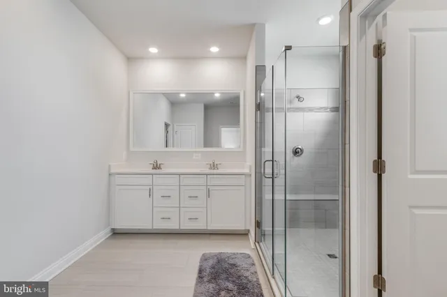 a spacious bathroom with a shower a sink and a mirror