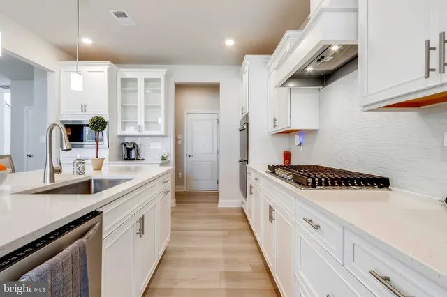 a kitchen with stainless steel appliances a sink stove and cabinets