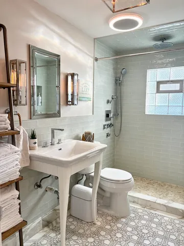 a bathroom with a sink toilet and a mirror