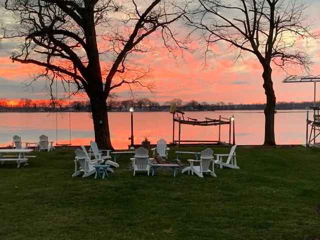a backyard of a house with table chairs and lake view