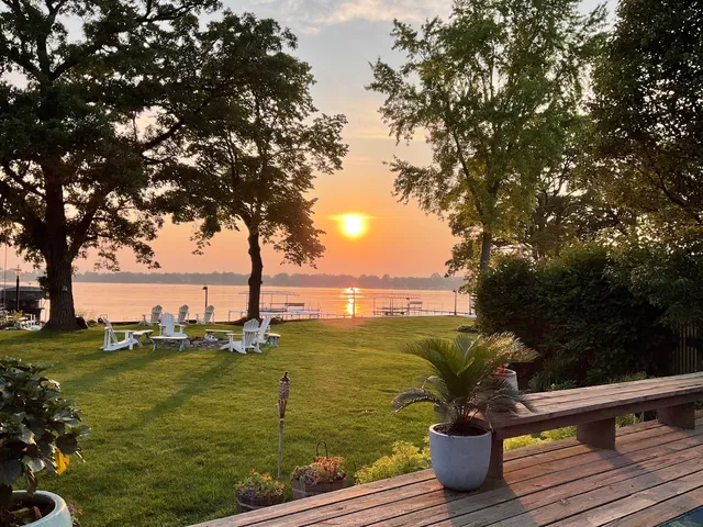 a view of a water fountain and a bench in a lake