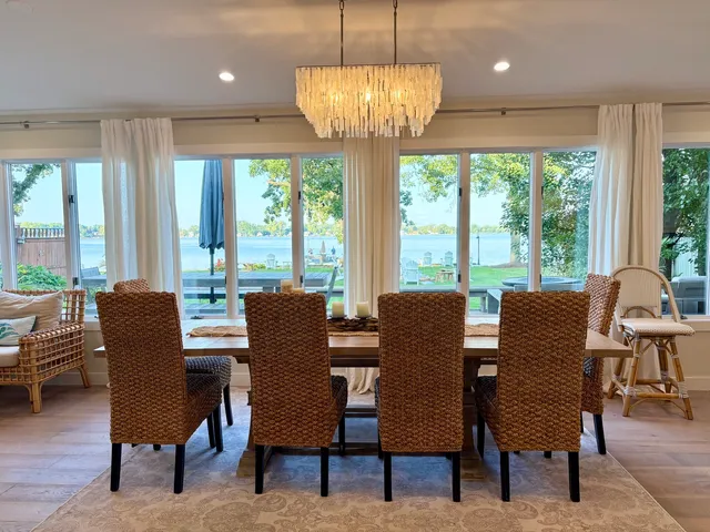 a dining room with furniture a chandelier and wooden floor