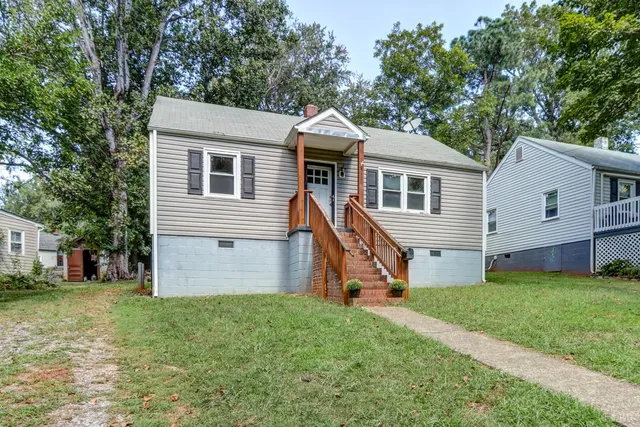 a front view of a house with a yard and trees