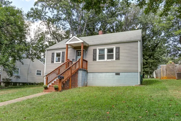 a view of a house with a yard and a large tree