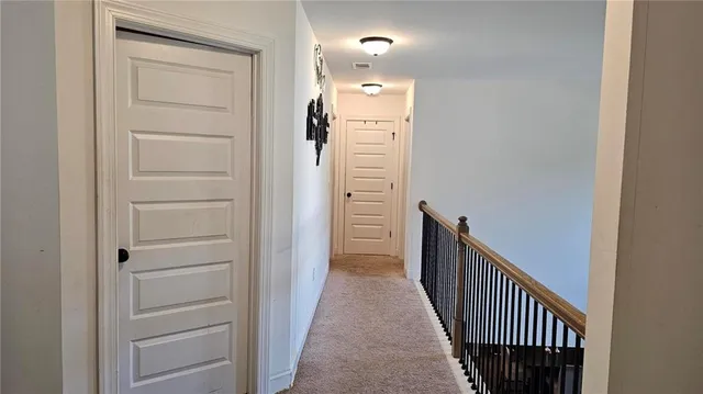 a view of a hallway with wooden floor and entryway