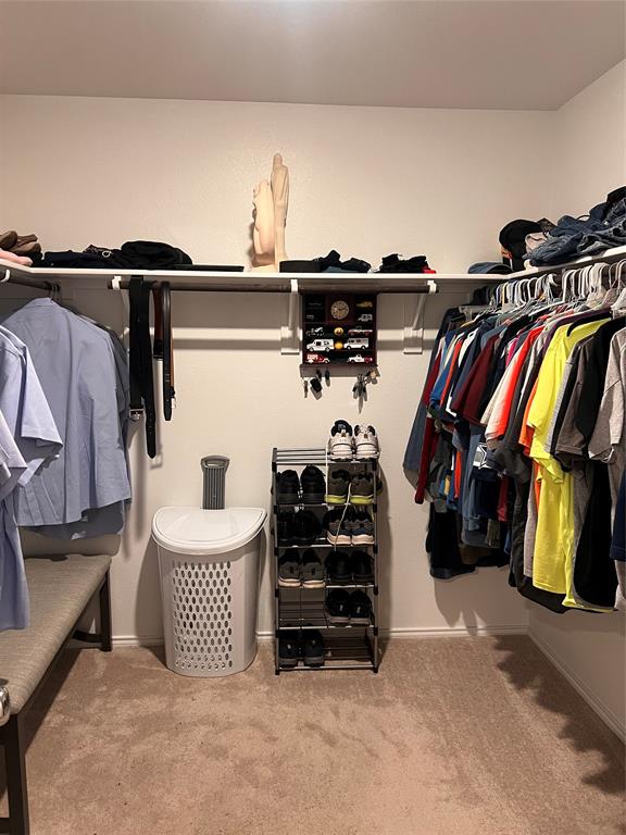 14941 Trapper Trail Haslet, TX 76052 - Photo 14 of 22 a view of walk in closet with clothes and shoes