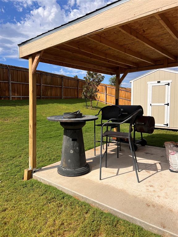 14941 Trapper Trail Haslet, TX 76052 - Photo 20 of 22 a view of a patio with table and chairs under an umbrella with a grill