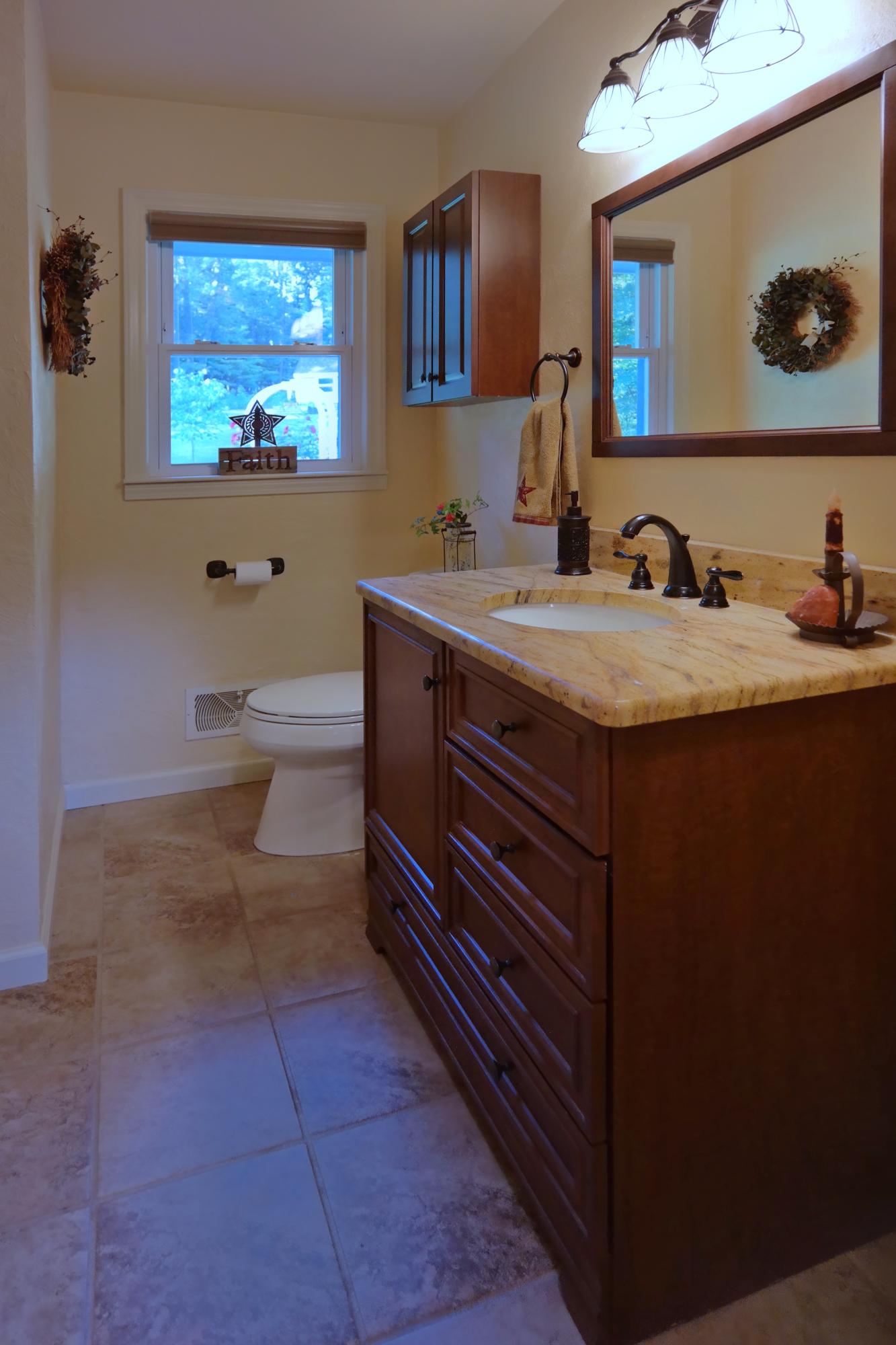 2144 Blue Ridge Springs Road Blue Ridge, VA 24064 - Photo 23 of 35 a bathroom with a granite countertop sink a mirror and a toilet