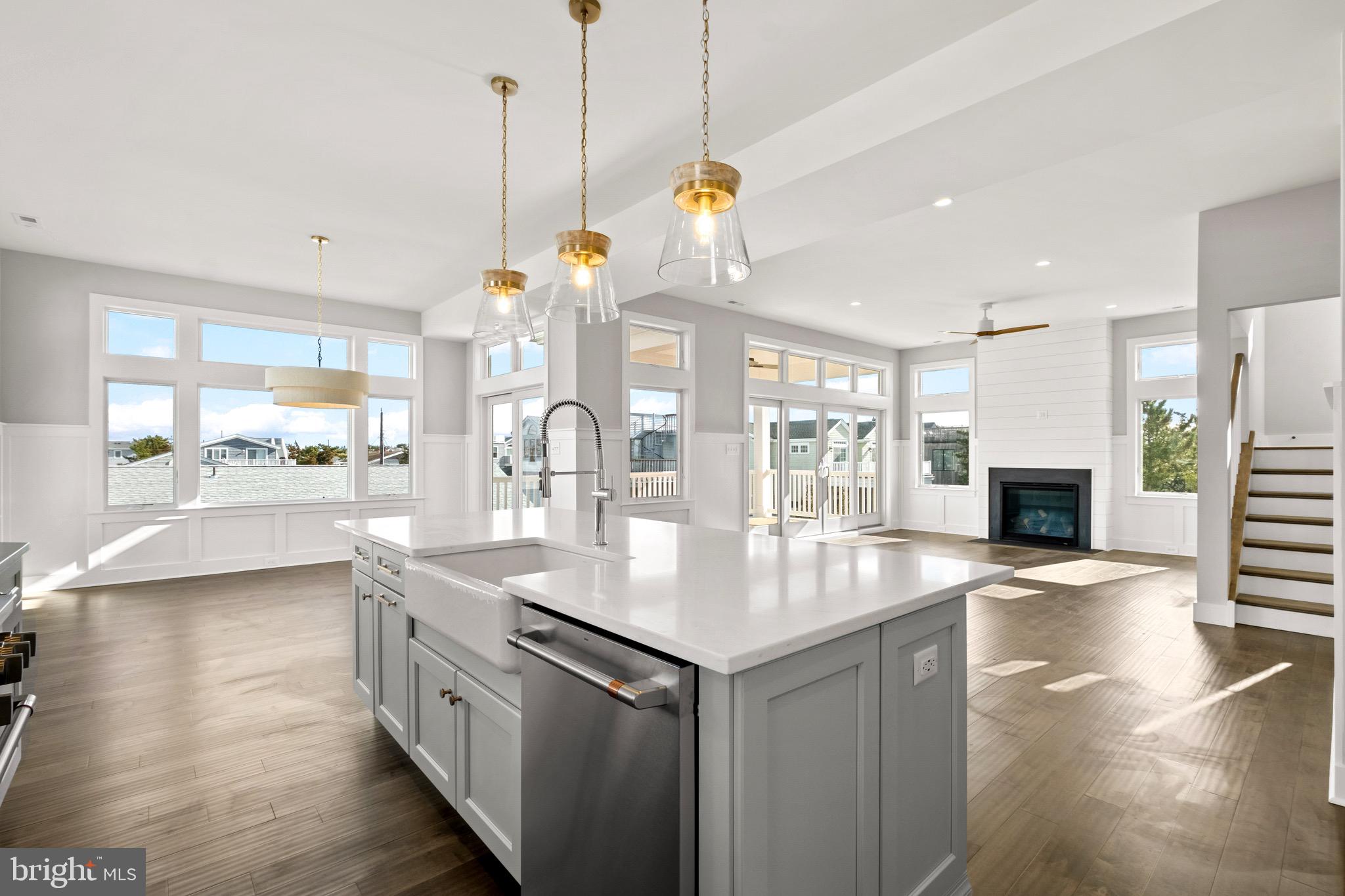 a large kitchen with kitchen island a large counter space a sink appliances and living room view
