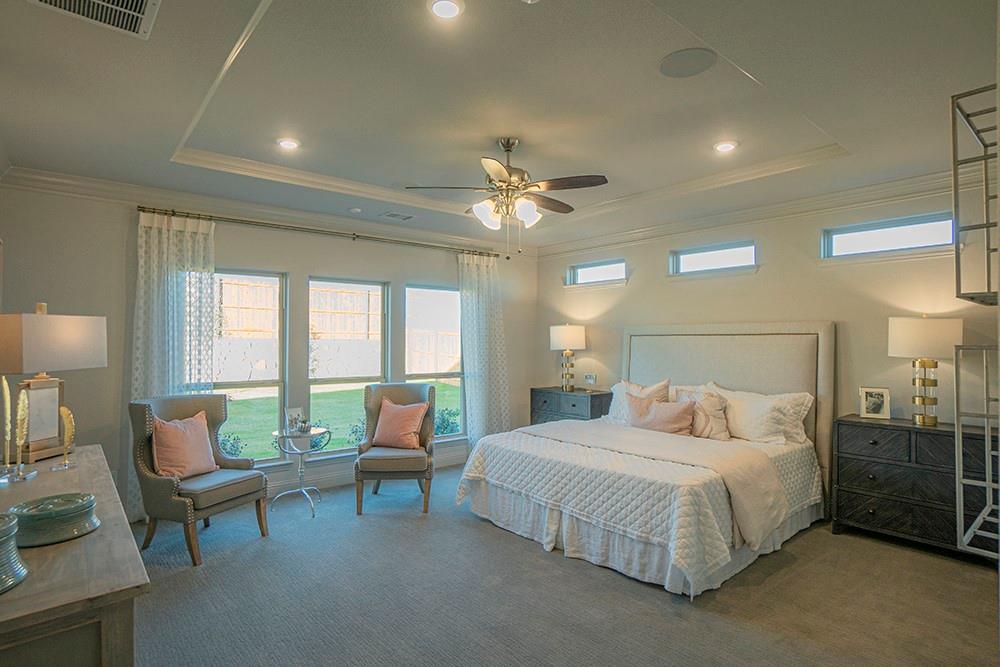 330 Aeronca Drive Fate, TX 75087 - Photo 11 of 32 a bedroom with a bed a couch and a chandelier