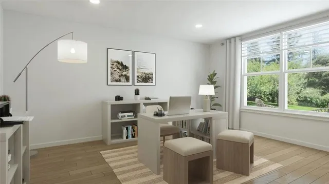 a view of a workspace with furniture and a window