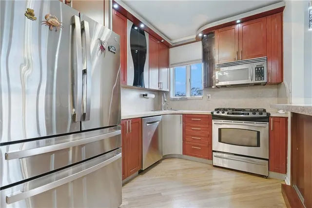 a kitchen with stainless steel appliances granite countertop a refrigerator and a stove top oven