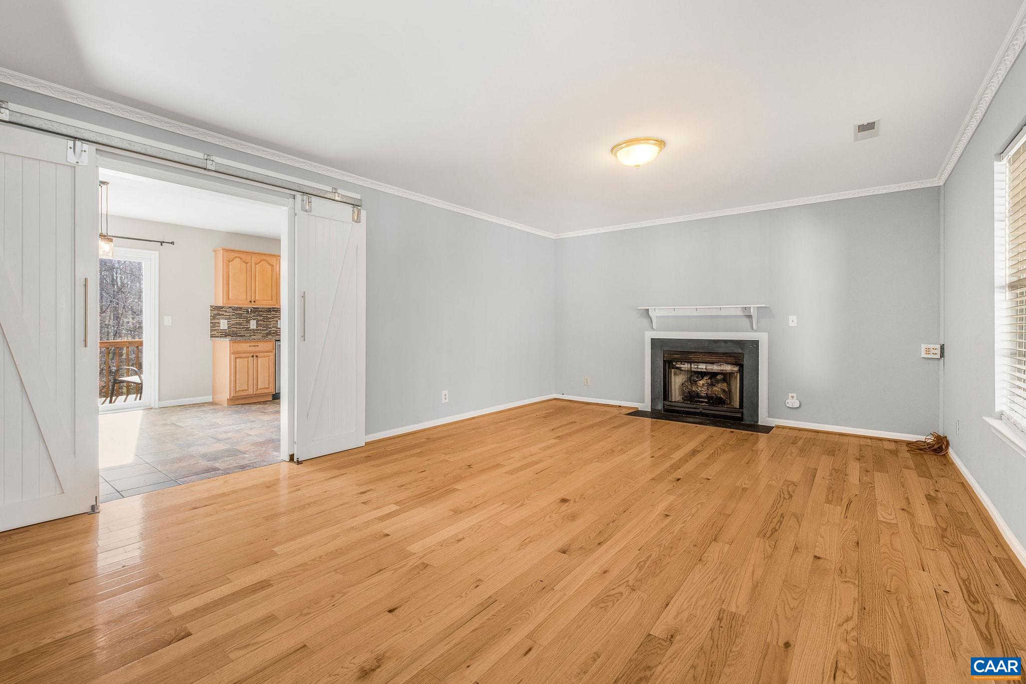 462 Fox Hunters Lane Madison, VA 22727 - Photo 16 of 65 a view of empty room with wooden floor and fireplace