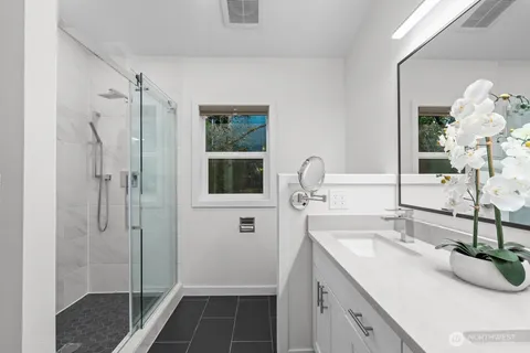 a bathroom with a shower sink and mirror