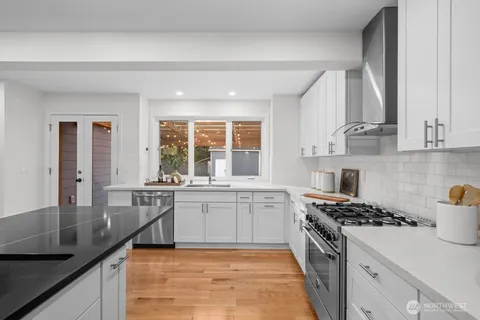 a kitchen with granite countertop a sink stove top oven and cabinets