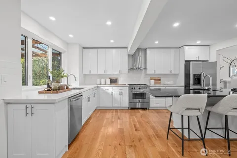 a kitchen with a sink stainless steel appliances and window
