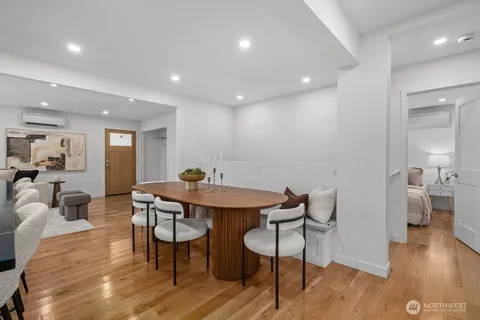 a view of a a dining room with furniture wooden floor and a chandelier