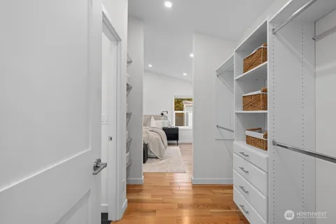 a hallway with white cabinets and wooden floor