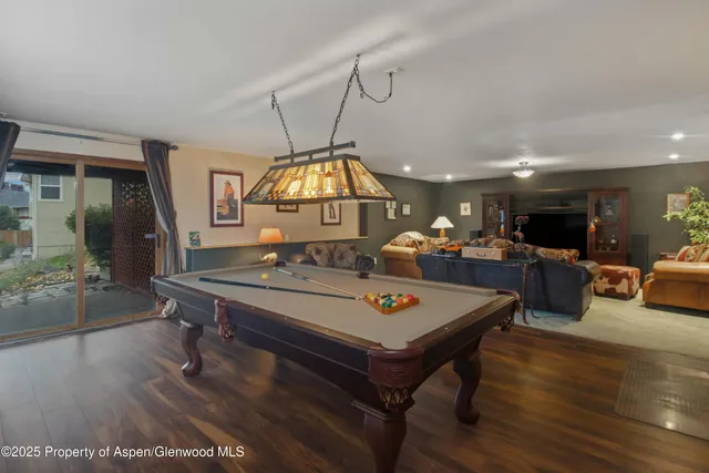 a bedroom with a large bed a flat tv screen and a large window