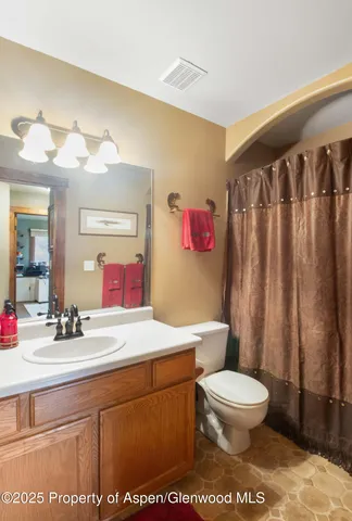 a bedroom with a bed table flowerpot and window
